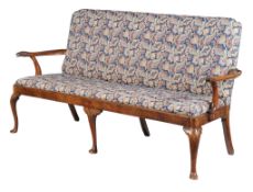 A George I walnut and upholstered settee, circa 1720, the shaped rectangular back and seat flanked