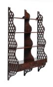 A Regency flight of wall hanging shelves , circa 1815, of waterfall type, with pierced lattice