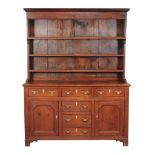 A pine dresser, late 18th/ early 19th century, the rack with a moulded cornice above three open