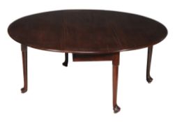 A George II mahogany oval drop leaf dining table, circa 1750, the oval top with a moulded edge and