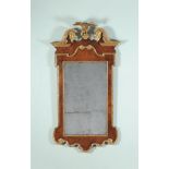 A George II walnut and parcel gilt gesso wall mirror, circa 1735, the rectangular plate within the