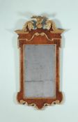 A George II walnut and parcel gilt gesso wall mirror, circa 1735, the rectangular plate within the