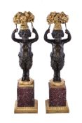 A pair of patinated and gilt bronze and porphyry mounted figural candlesticks in Louis XVI style,