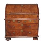 A Queen Anne walnut bureau, circa 1710, the hinged fall enclosing a concealed well and an