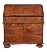 A Queen Anne walnut bureau, circa 1710, the hinged fall enclosing a concealed well and an