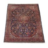 A Kashan carpet, the navy field decorated with an overall design incorporating flowerheads and