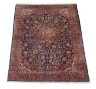 A Kashan carpet, the navy field decorated with an overall design incorporating flowerheads and