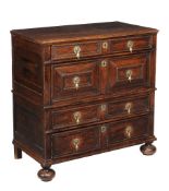 A Charles II oak chest of drawers, circa 1660, the planked rectangular top with four mitre panelled