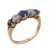A sapphire and diamond ring, the central circular cut sapphire between two old brilliant cut