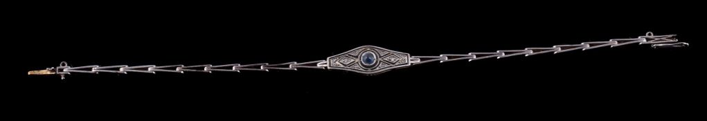 An Edwardian diamond and sapphire bracelet, circa 1910, the central circular cabochon sapphire on