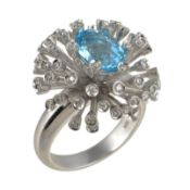 A blue topaz and diamond ring, the central oval cut blue topaz within a cluster surround set with