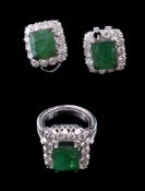 An emerald and diamond ring, the central rectangular cut emerald claw set within a surround of
