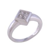 A diamond ring, the square panel set with four square cut diamonds, approximately 0.25 carats