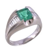 An emerald and diamond ring, the central rectangular cut emerald claw set between baguette cut