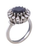 A 1970s sapphire and diamond cluster ring, the central circular cut sapphire claw set within a