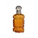 A Victorian silver mounted amber cut glass scent bottle, unmarked, mid 19th century, with a lobed