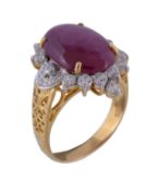 A ruby and diamond ring, the oval cabochon ruby claw set within a surround of brilliant cut