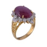 A ruby and diamond ring, the oval cabochon ruby claw set within a surround of brilliant cut