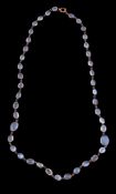 An early 20th century moonstone necklace, the graduating oval cabochon moonstones in collet