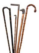 Six various walking sticks, the first circa 1900, the handle of plain curved horn, the shaft of