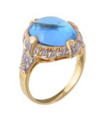 A blue topaz and diamond ring, the oval cabochon blue topaz within a surround of brilliant cut