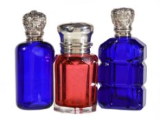 Three late Victorian silver mounted coloured glass scent bottles, one late Victorian cranberry by