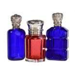 Three late Victorian silver mounted coloured glass scent bottles, one late Victorian cranberry by