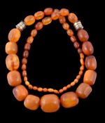 An amber and amber coloured bead necklace, composed of graduating amber and amber coloured beads,
