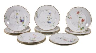 Sixteen Limoges porcelain dessert plates, early 20th century, painted with flowers within a shaped