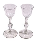 A pair of engraved facet stemmed wine glasses , late 18th century, the ogee bowls with everted rims