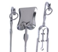 An Arts and Crafts set of three polished steel fire tools, with twist rings to the terminals and