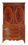 Ω A mahogany and line inlaid clothes press , circa 1815 and later, the oval panel doors with