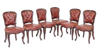 A set of six mahogany and buttoned red leather upholstered chairs, circa 1870, each back surmounted