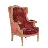 A giltwood wing armchair in Louis XVI style , early 20th century, with crimson damask velvet
