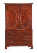 Ω A George III mahogany and tulipwood banded linen press , circa 1800, the oval panel doors