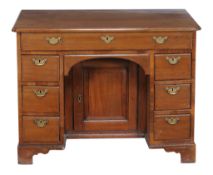 A George III mahogany kneehole desk, circa 1780, with an arrangement of seven drawers, centred by