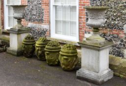 A pair of stone composition garden urns on plinths, second half 20th century, of Campana form with