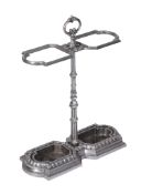 A Victorian polished iron stick stand, late 19th century, with foliate cast loop handle above twin
