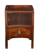 A George III mahogany bedside night commode, circa 1790, of concave outline and with tambour door,