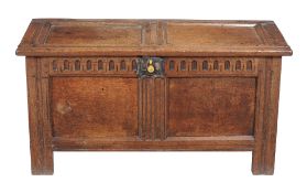 A Charles II oak panelled chest, circa 1660, the carved frieze incorporating fluted decoration,