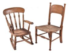 A late Victorian or Edwardian beech child's rocking chair, circa 1900, the back with turned