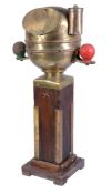 A ships stern binnacle, with polished brass hood enclosing the binnacle compass flanked by red and