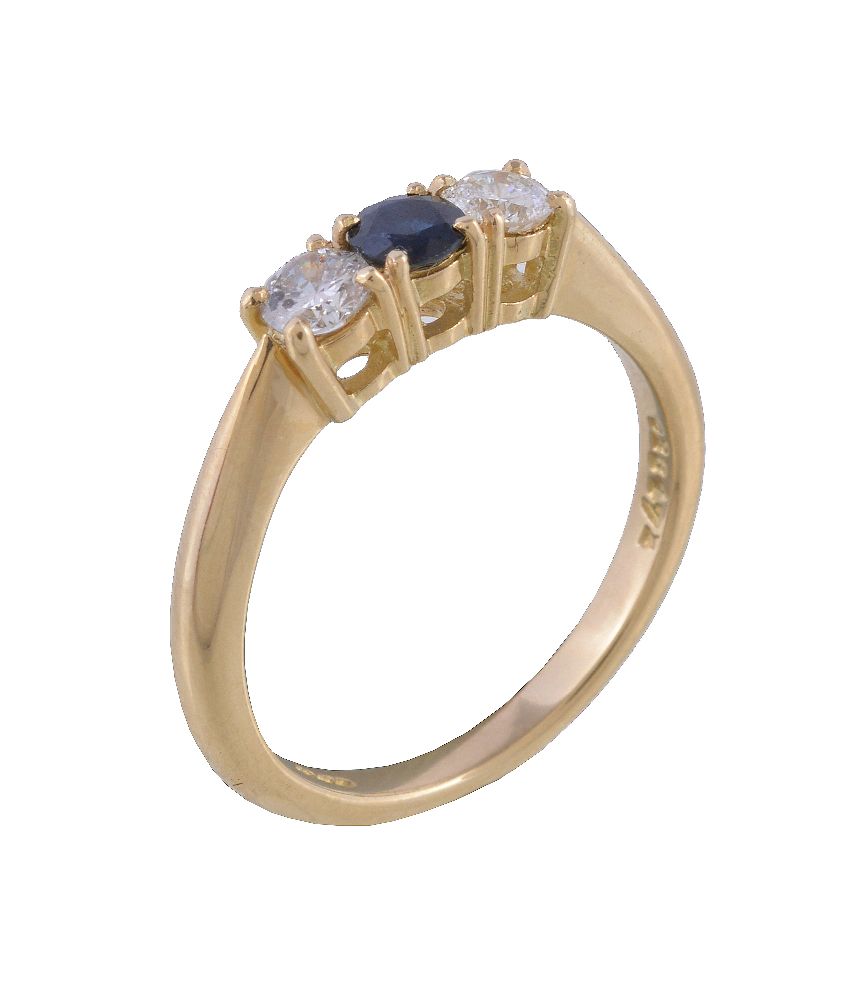 A sapphire and diamond ring, the central circular cut sapphire claw set between two brilliant cut