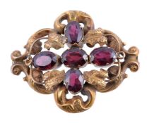 An early Victorian garnet brooch, circa 1850, the scrolled foliate panel set with oval cut