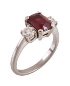 A ruby and diamond three stone ring, the step cut ruby flanked by brilliant cut diamonds,