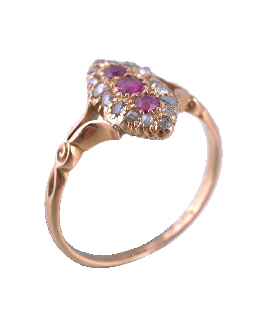 An Edwardian ruby and diamond ring, the marquise shaped panel set with three graduated oval cut