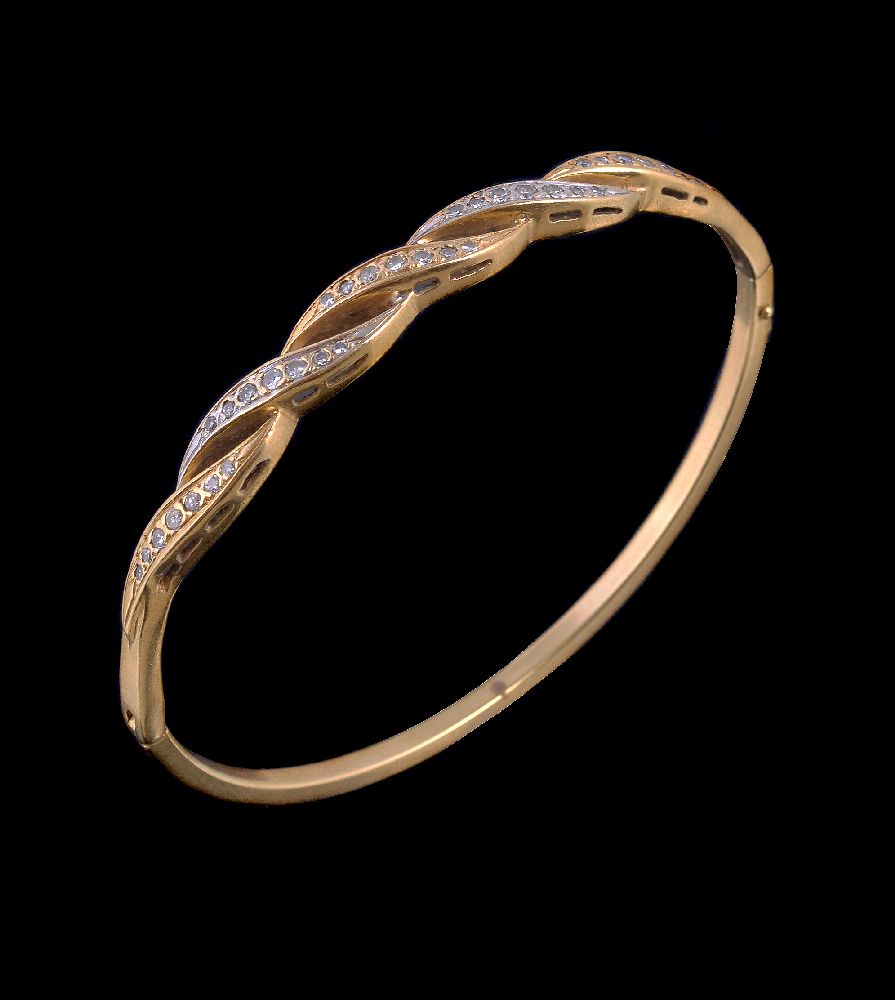 A diamond hinged bangle, the pierced rope twist style panel set with graduating brilliant cut