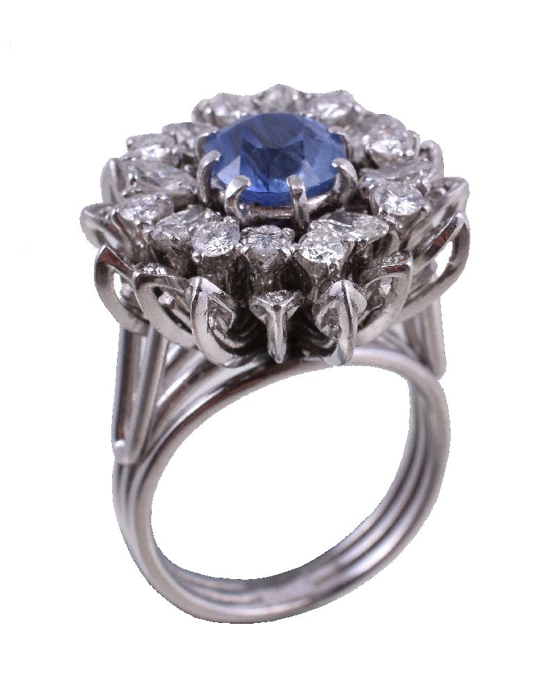A 1960s diamond and sapphire flower head ring, the cushion cut sapphire within a surround of
