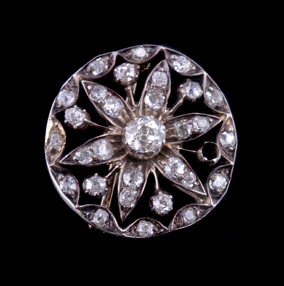 A late Victorian diamond brooch, circa 1890, the circular openwork brooch set with old cut diamonds,