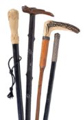 Y Four various walking sticks, the first ivory mounted, circa 1880,